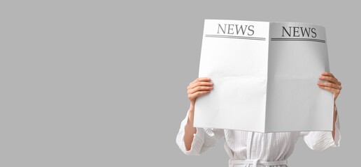Woman holding newspaper on grey background with space for text
