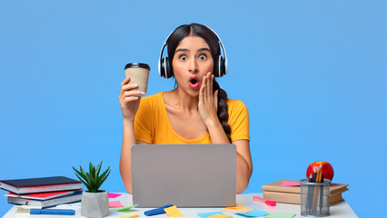 Deadline Concept. Portrait of shocked surprised indian female student in headphones sitting at desk...
