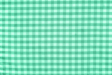 Beige checkered tablecloth as background, closeup