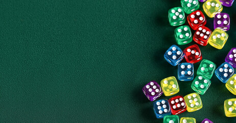 Many colorful dices on green background with space for text