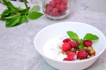 Healthy breakfast. Granola with pumpkin seeds, honey, yogurt and fresh berries in a ceramic bowl on white background.