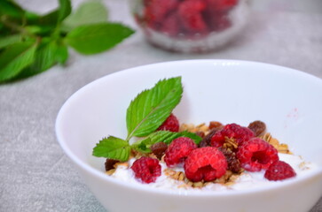 Healthy breakfast. Granola with pumpkin seeds, honey, yogurt and fresh berries in a ceramic bowl on white background.