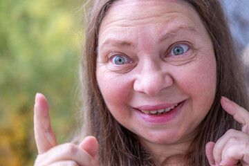 vibrant, joyful woman in her 50s smiles genuinely, cheerful female joyful presence, Embracing life,...