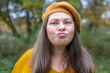 Happy senior woman enjoying fall season in warm beret, in autumn wearing cozy clothes in golden...