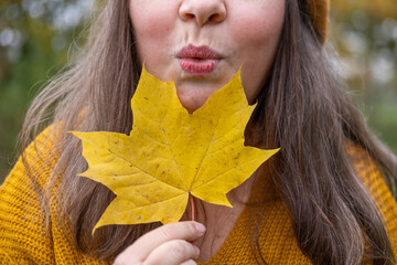 Happy mature woman with fall leaf in hand, Elegant senior lady, park background, vibrant aging,...