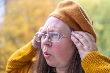 mature woman suffering from severe migraine, holding head in pain, pained expression, migraine attack, close-up distressed face, emotional struggle