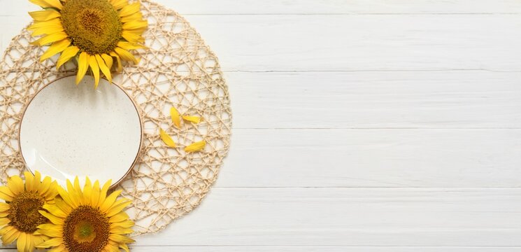 Beautiful table setting with sunflowers on white wooden background with space for text