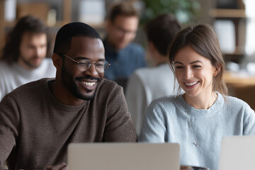 Diverse Smiling Team Collaborating on Laptop in Modern Office