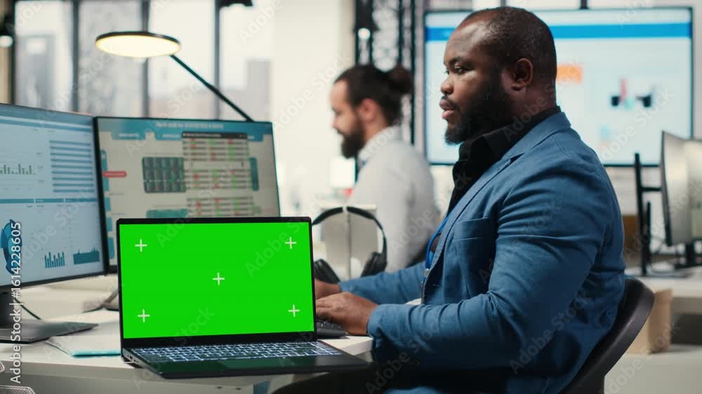 Poster black analyst uses computer to analyze charts with chroma key on laptop, preparing strategy reports 