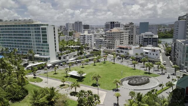 Drone lowers over viewpoint facing La Ventana al Mar Park covered in palm trees on sunny morning in San Juan, Puerto Rico