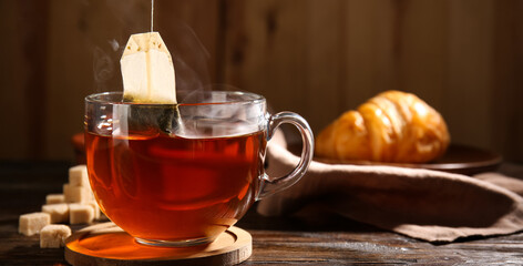 Cup of hot tea with sugar on table, closeup