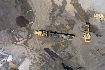 Excavators trucks operate on vast gravel extraction site under industrial mining process