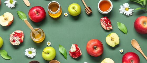 Frame made of fresh fruits honey and flowers on green background. Rosh hashanah (Jewish New Year)...