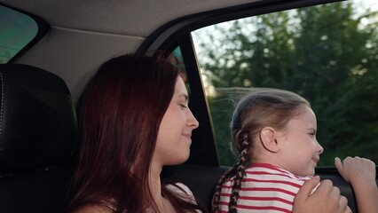 happy child girl mom looking out car window, happy faces mother child daughter, kid parent back...