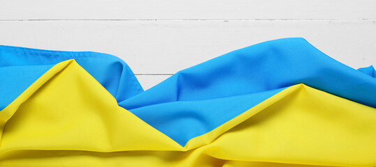 Flag of Ukraine on white wooden background with space for text