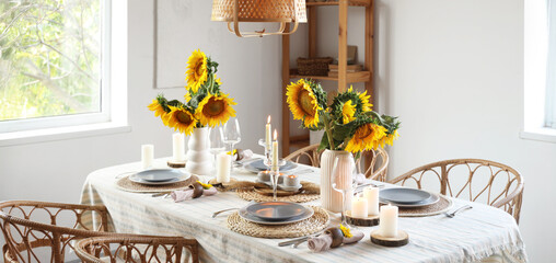 Vases with beautiful sunflowers on served table