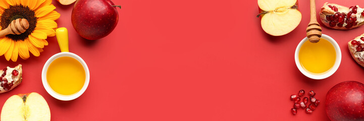 Jar of honey with pomegranate and apples for Rosh Hashanah celebration (Jewish New Year) on red background