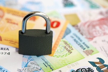 Nigerian naira currency money bills and padlock. The concept of sanctions and financial safety