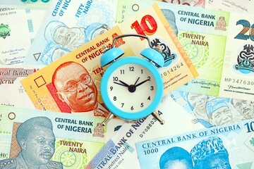 Nigerian naira currency money bills and alarm clock. The concept of time management and income