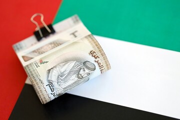 United Arab Emirates dirham currency money bills lies on flag. The concept of business and...