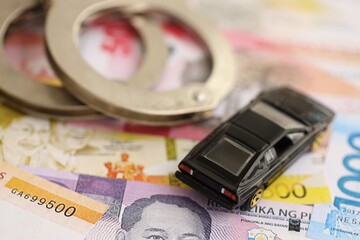 Philippines peso currency money bills and toy car with handcuffs. The concept of car accident