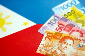Philippines peso currency money bills lies on flag. The concept of business and investment