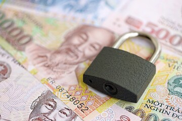 Vietnamese dong currency money bills and padlock. The concept of sanctions and financial safety