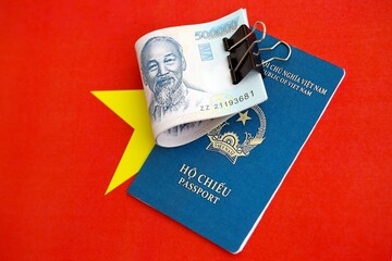 Vietnamese dong currency money bills and passport lies on flag. The concept of travel and vacation