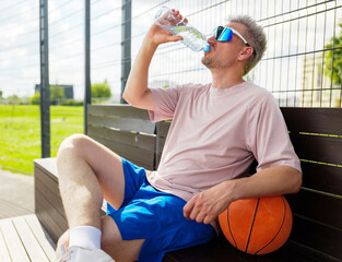 Refreshing break after a spirited basketball practice session outdoors