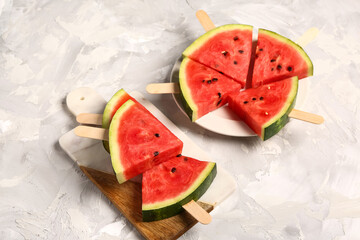 Plate and board with sweet watermelon sticks on grunge background