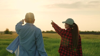 agriculture industry, two farmers work green field at sunset, field wheat, growing green plants, senior agronomist talks about work modern farming, commercial activities, financial investments - Powered by Adobe