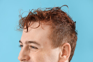 Obraz premium Young man with wet hair on light blue background