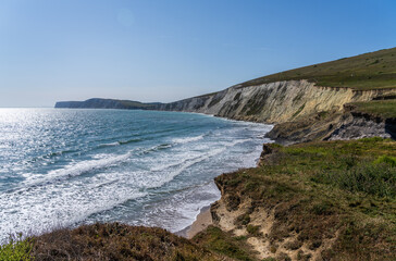Eroding cliffs in the area known as Dinosaur Coast collapse into the ocean in Compton Bay on the...