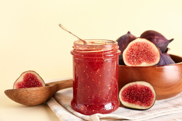 Jar of sweet fig jam on yellow background