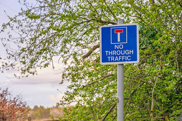 No Through Road sign with blue background on rural roadside