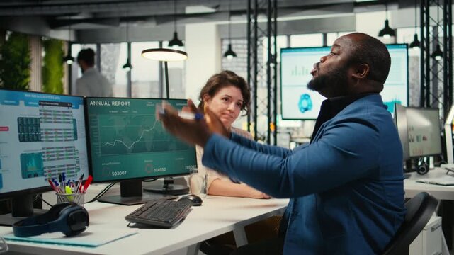 Exasperated black manager dealing with a stressful situation at the office, worried stressed woman colleague trying to calm him down and showing empathy. Trying to avoid a bigger crisis. Camera A.