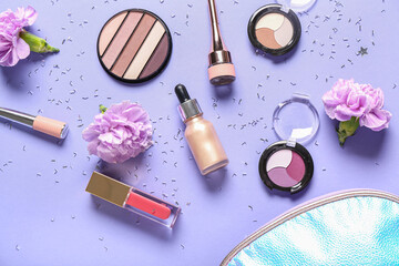 Cosmetic bag with makeup products, flowers and confetti on lilac background
