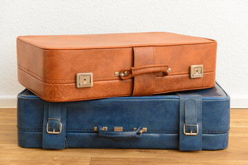 Blue and brown retro leather suitcases on floor in room