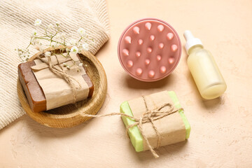 Hair scalp massager with shampoo bars and cosmetic oil on grunge beige background