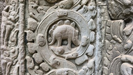 Ta Prohm, Cambodia - 3 July 2025. Detailed carving on a temple pillar depicting an animal shape...