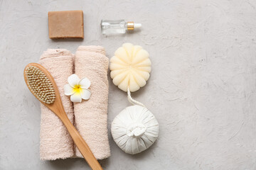 Composition with bath supplies, herbal bag, plumeria flower and bottle of essential oil on grunge...