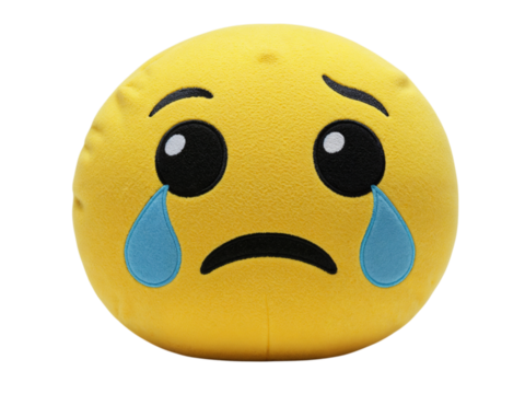 A sad emoji pillow with tears rolling down its cheeks isolated on transparent background