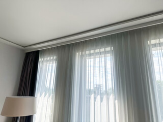 Beautiful curtains hanging on cornice near window indoors, low angle view