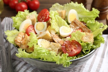 Delicious salad with croutons, chicken, quail eggs, tomato and cheese on table, closeup