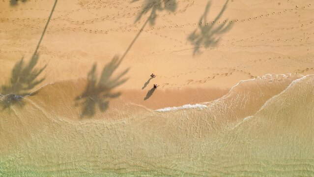 Top down drone shot above two womans walking on a Beach