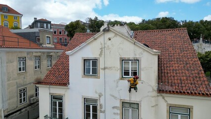 Aerial view of a climber painting a building