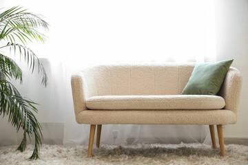 Interior of stylish living room with sofa, houseplant and light curtains