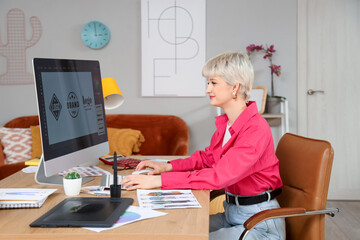 Female graphic designer working with computer at table in office