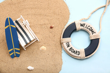 Deckchair, surf board, sand and lifebuoy ring on blue background. Summer concept