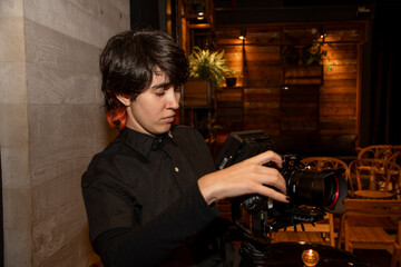 Primer plano de joven con cámara en mano y monitor digital filmando secuencia en fiesta
